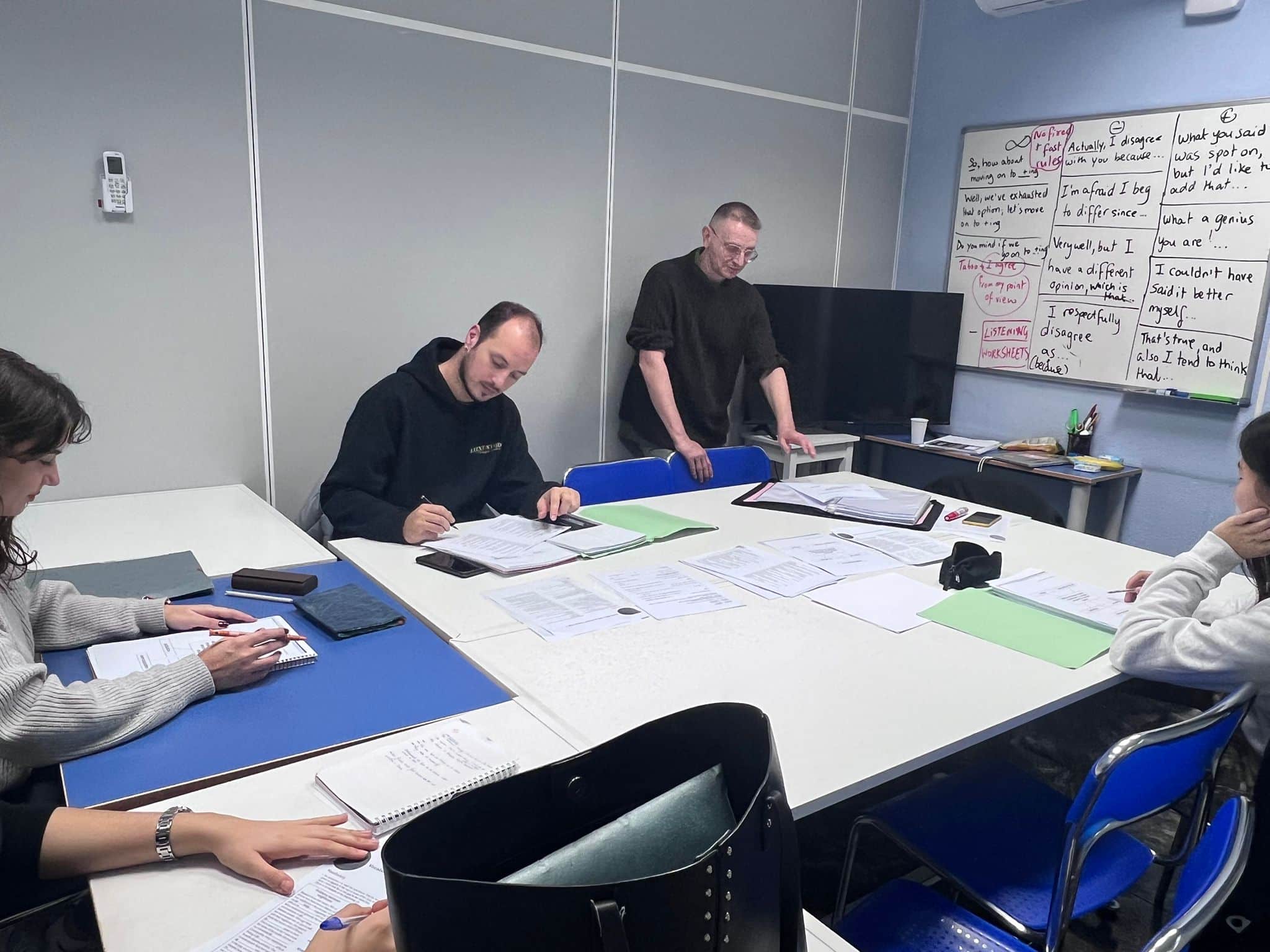 Profesor nativo y alumnos trabajando con ejercicios reales de Cambridge en Campus Study Centre, academia de inglés en la zona universitaria de Valencia.